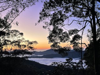 High photo of a sunrise over the misty valley with mountains going into the distance