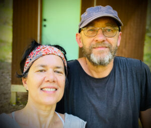 Close up photo of Raven and Paul in front of the tiny hut